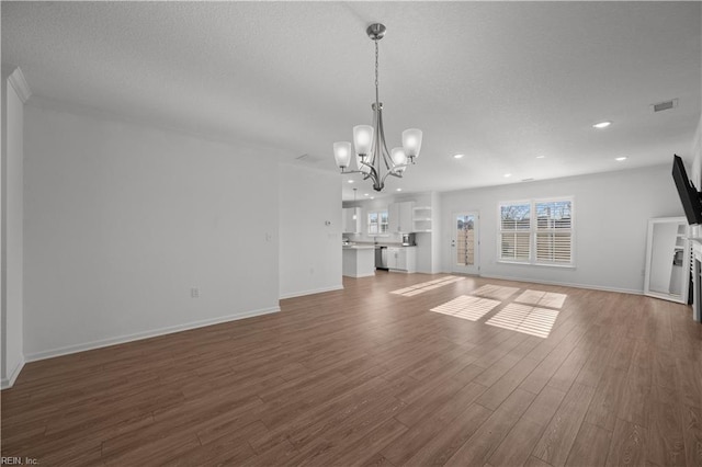 unfurnished living room with a chandelier, recessed lighting, a textured ceiling, and wood finished floors