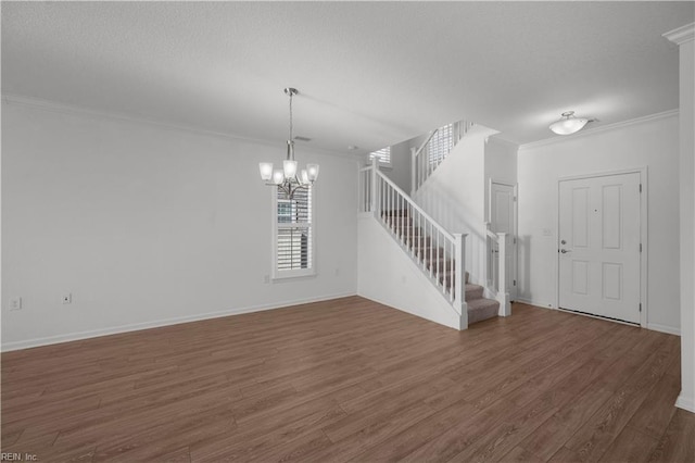 interior space featuring an inviting chandelier, crown molding, stairs, and wood finished floors