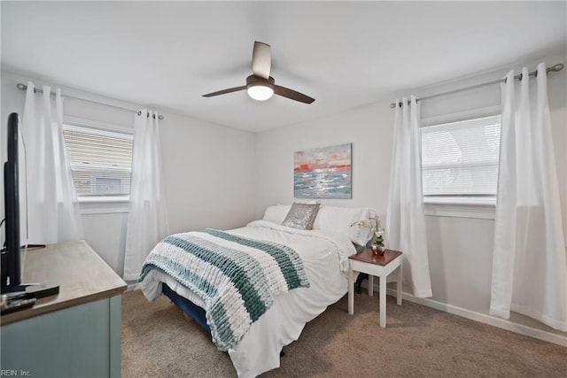 bedroom featuring ceiling fan, carpet floors, multiple windows, and baseboards