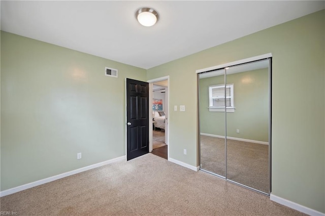 unfurnished bedroom with a closet, baseboards, visible vents, and carpet flooring