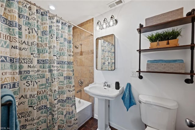 full bath featuring toilet, shower / bath combo with shower curtain, and visible vents