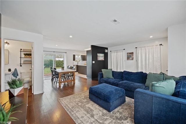 living area featuring recessed lighting, dark wood-style flooring, visible vents, and baseboards