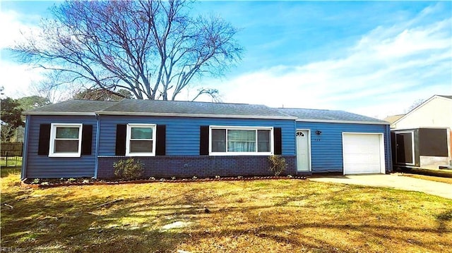 single story home featuring a garage, a front yard, brick siding, and driveway