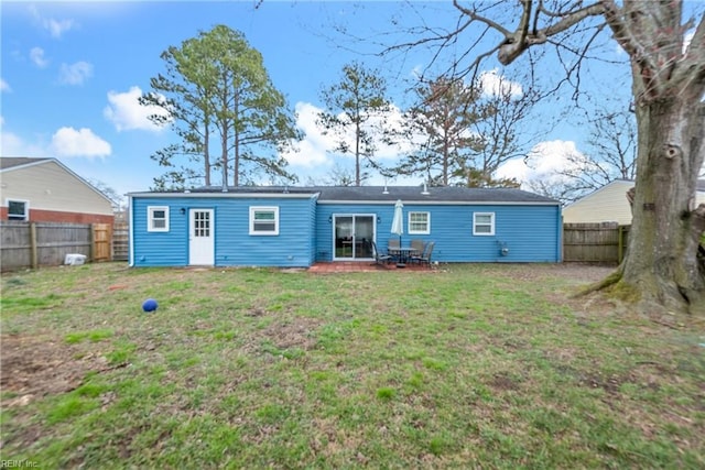 rear view of house featuring a fenced backyard and a yard