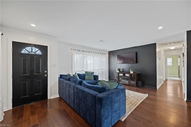 living area featuring baseboards, dark wood-type flooring, and recessed lighting