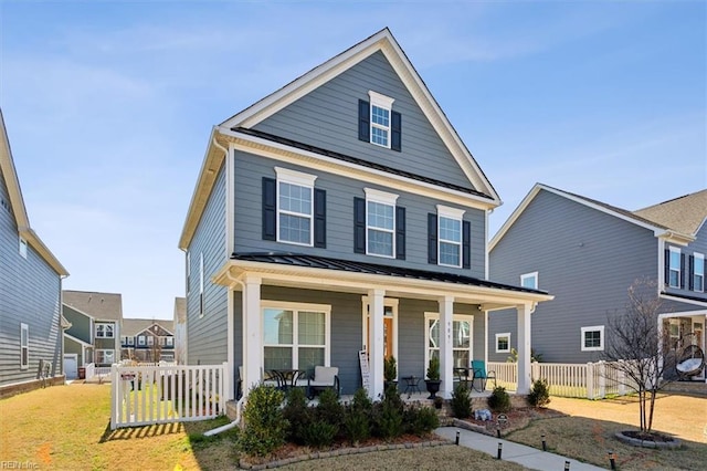 view of front of house featuring metal roof, a standing seam roof, fence, a porch, and a front yard