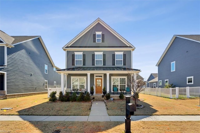 view of front facade featuring a standing seam roof, metal roof, fence, and a porch