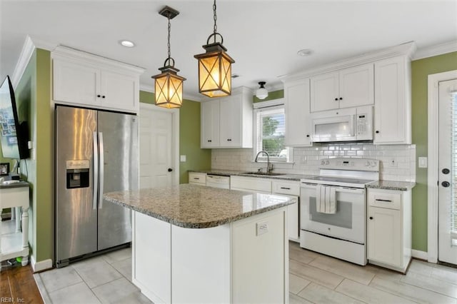 kitchen with decorative backsplash, ornamental molding, white cabinets, a sink, and white appliances