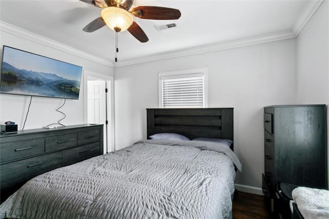 bedroom with ceiling fan, wood finished floors, visible vents, baseboards, and crown molding