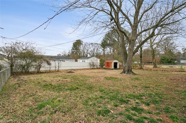 view of yard featuring a storage shed, a fenced backyard, and an outdoor structure