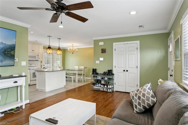 living room with ornamental molding, wood finished floors, and recessed lighting