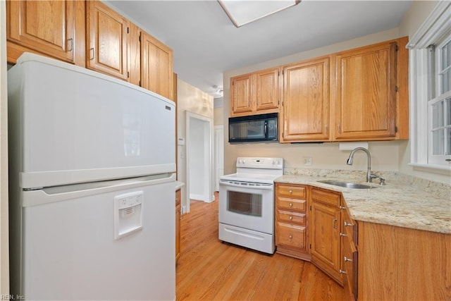 kitchen featuring white appliances, light wood-type flooring, a sink, and light stone countertops