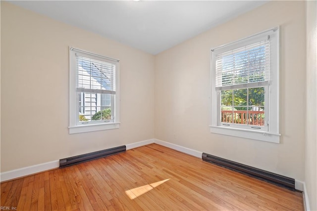 spare room featuring light wood-style floors, baseboards, and baseboard heating