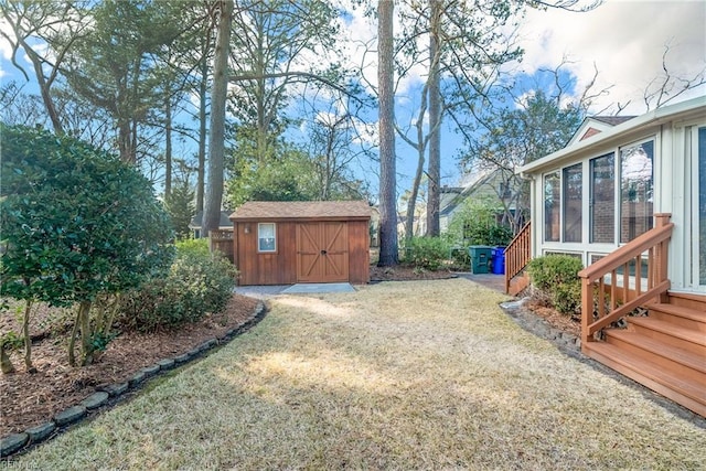 view of yard with driveway, a storage shed, a sunroom, and an outdoor structure