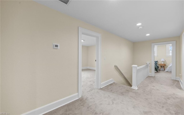 hall featuring visible vents, baseboards, an upstairs landing, carpet floors, and recessed lighting