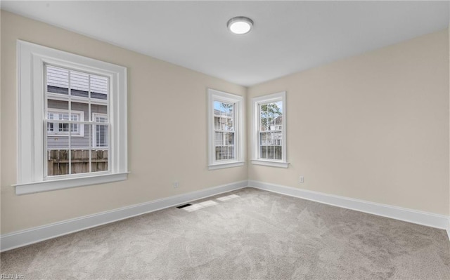 carpeted empty room with visible vents and baseboards