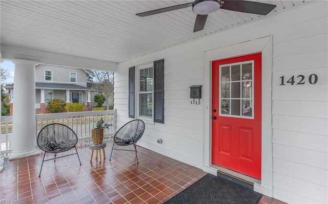 view of exterior entry featuring covered porch and a ceiling fan