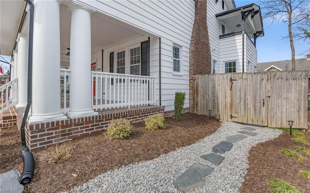 view of side of home with a porch and fence