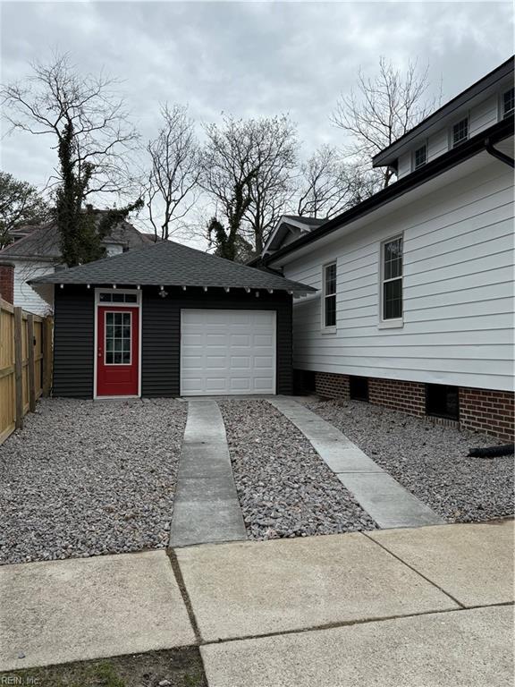 exterior space featuring a garage, concrete driveway, crawl space, and fence