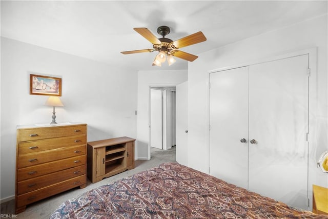 carpeted bedroom with ceiling fan and a closet