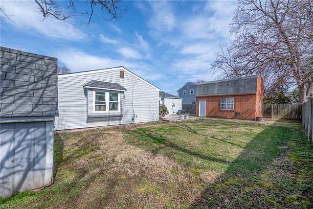 exterior space with an outbuilding, a yard, a patio area, and a fenced backyard