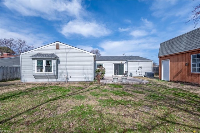 rear view of property featuring a patio, a yard, central AC, and fence