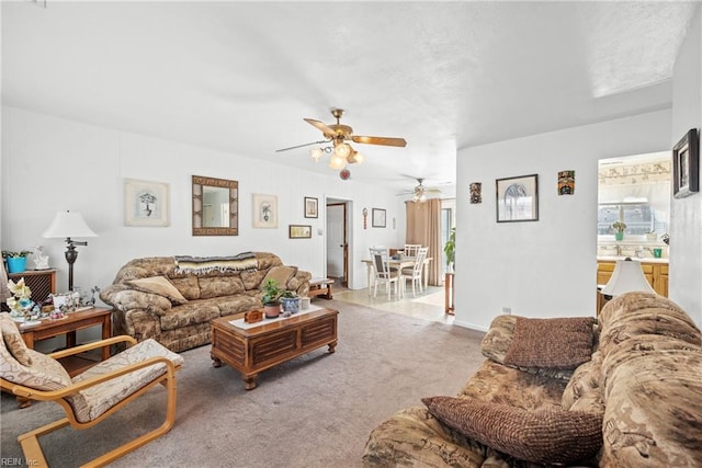 carpeted living area with ceiling fan