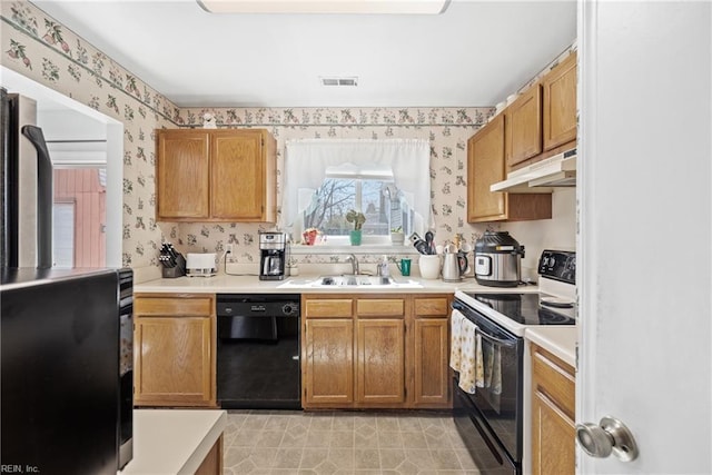 kitchen featuring wallpapered walls, dishwasher, under cabinet range hood, a sink, and range with electric stovetop