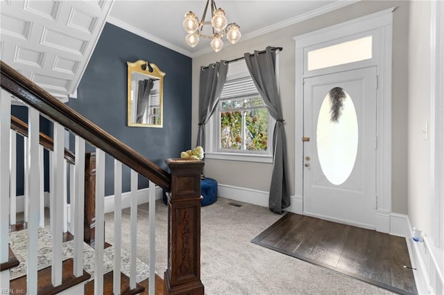 carpeted foyer featuring crown molding, visible vents, stairway, a chandelier, and baseboards