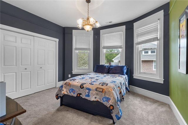 bedroom featuring a chandelier, carpet, a closet, and baseboards