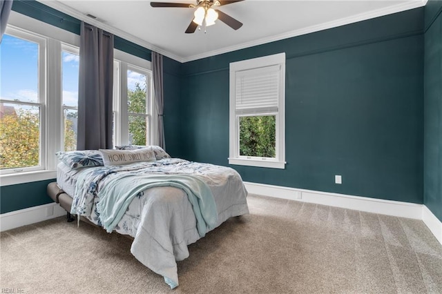 carpeted bedroom with ornamental molding, baseboards, and a ceiling fan