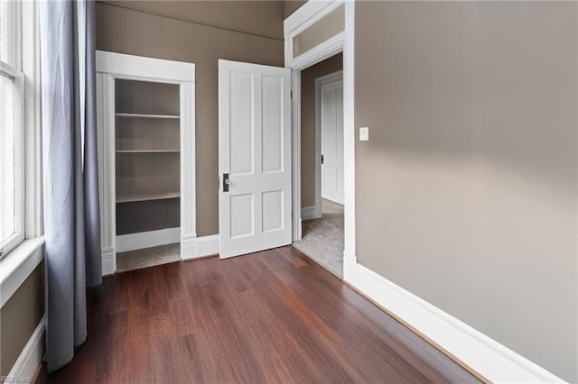 interior space with dark wood-style flooring and baseboards