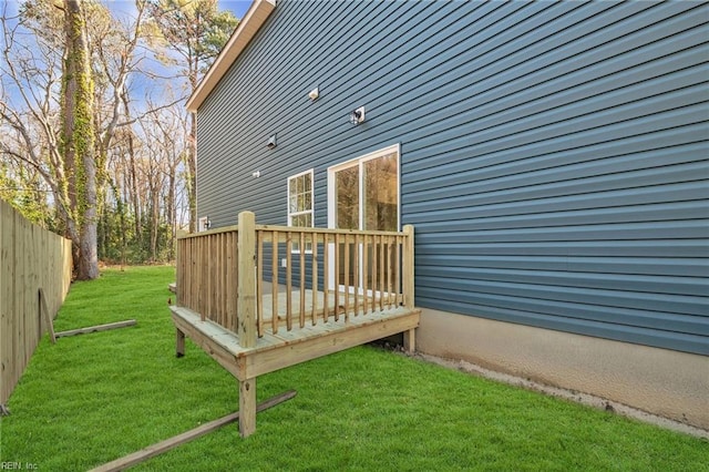 wooden terrace featuring fence and a lawn