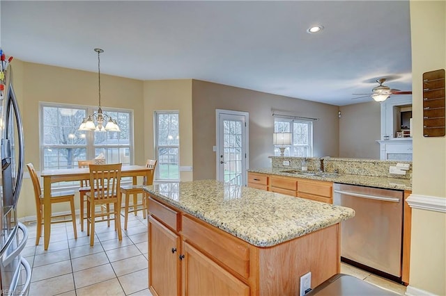 kitchen featuring light tile patterned floors, light stone countertops, stainless steel appliances, a sink, and a center island