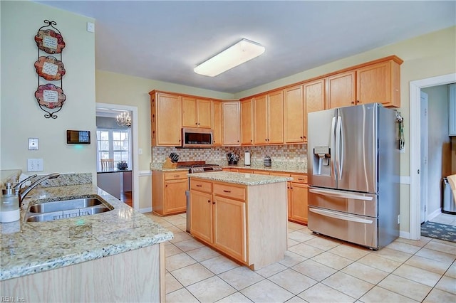 kitchen featuring tasteful backsplash, light stone counters, stainless steel appliances, and a sink