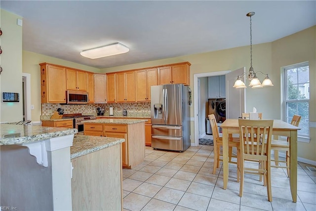 kitchen featuring appliances with stainless steel finishes, a center island, decorative backsplash, and light tile patterned floors