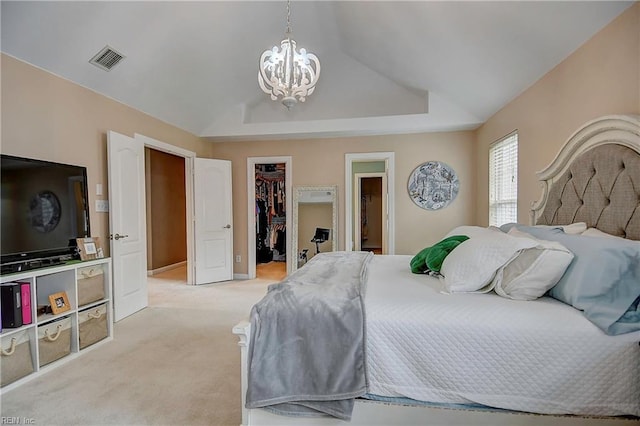 bedroom featuring visible vents, light colored carpet, a spacious closet, vaulted ceiling, and a closet