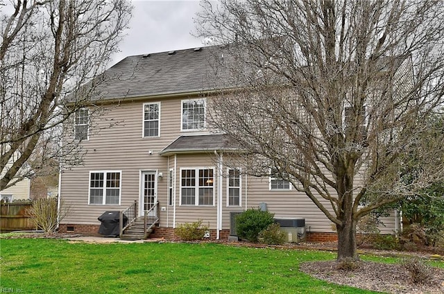 rear view of house featuring entry steps, crawl space, a lawn, and fence