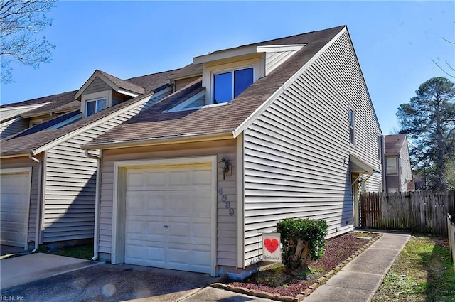 view of home's exterior with a garage and fence