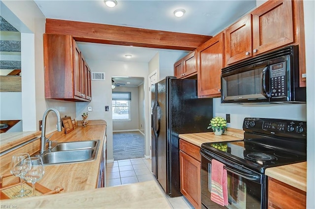 kitchen featuring light tile patterned floors, a sink, visible vents, a ceiling fan, and black appliances