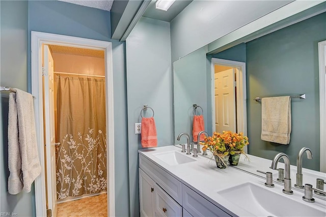 bathroom with curtained shower, a sink, and double vanity