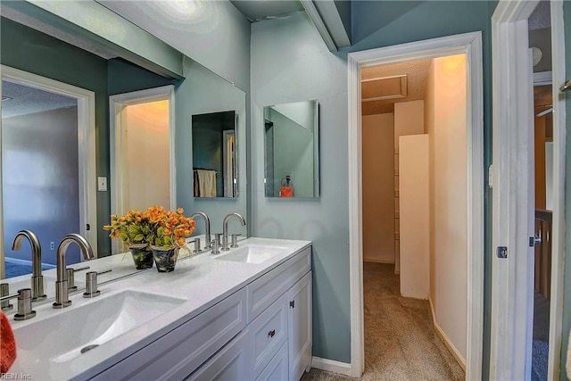 bathroom with double vanity, baseboards, and a sink