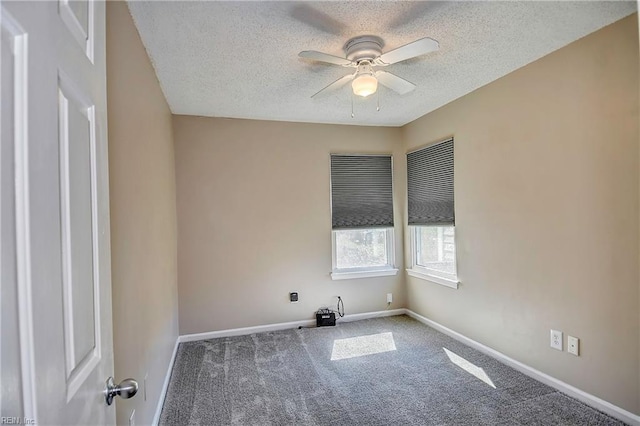 empty room featuring carpet, ceiling fan, a textured ceiling, and baseboards