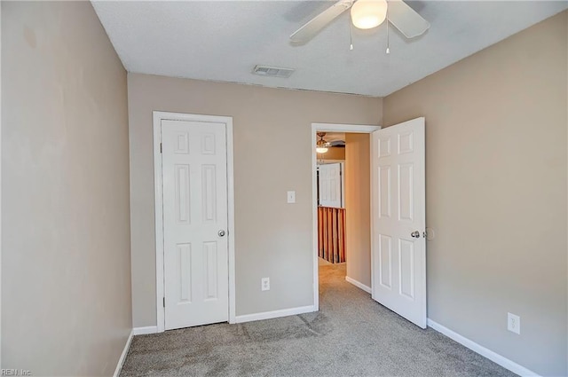 unfurnished bedroom featuring a ceiling fan, carpet, visible vents, and baseboards