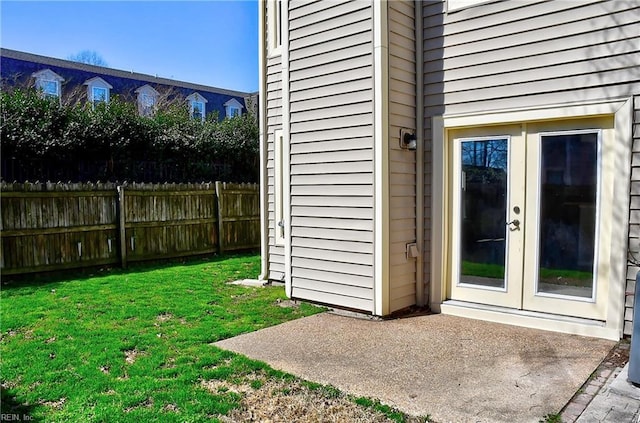 entrance to property with a yard, french doors, a patio area, and fence