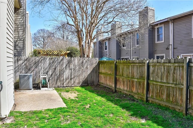 view of yard with a patio area, a fenced backyard, and central AC unit