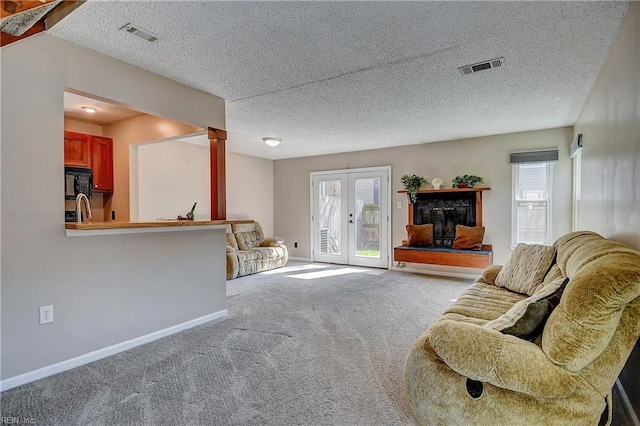 living room with carpet, french doors, visible vents, and baseboards