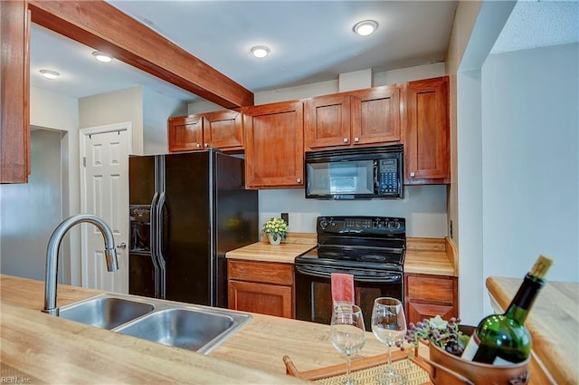 kitchen featuring light countertops, a sink, beamed ceiling, and black appliances