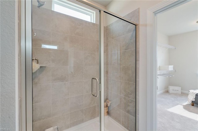 full bath with a shower stall and baseboards