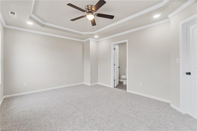 carpeted empty room featuring a tray ceiling, crown molding, recessed lighting, visible vents, and baseboards